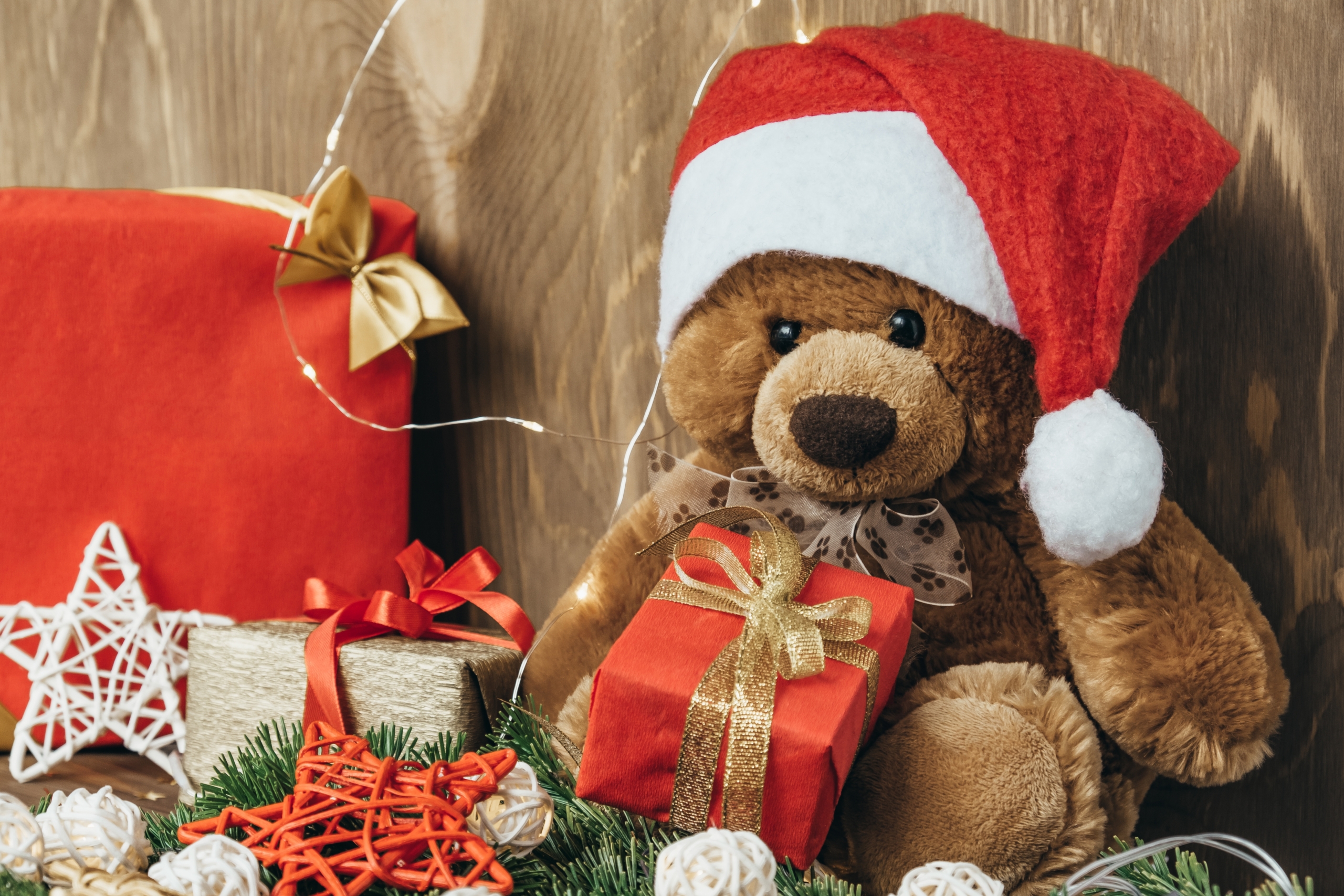 Christmas card with Santa bear, fir branches, garland, gifts and decorations. Selective focus. Close-up. Copy space.